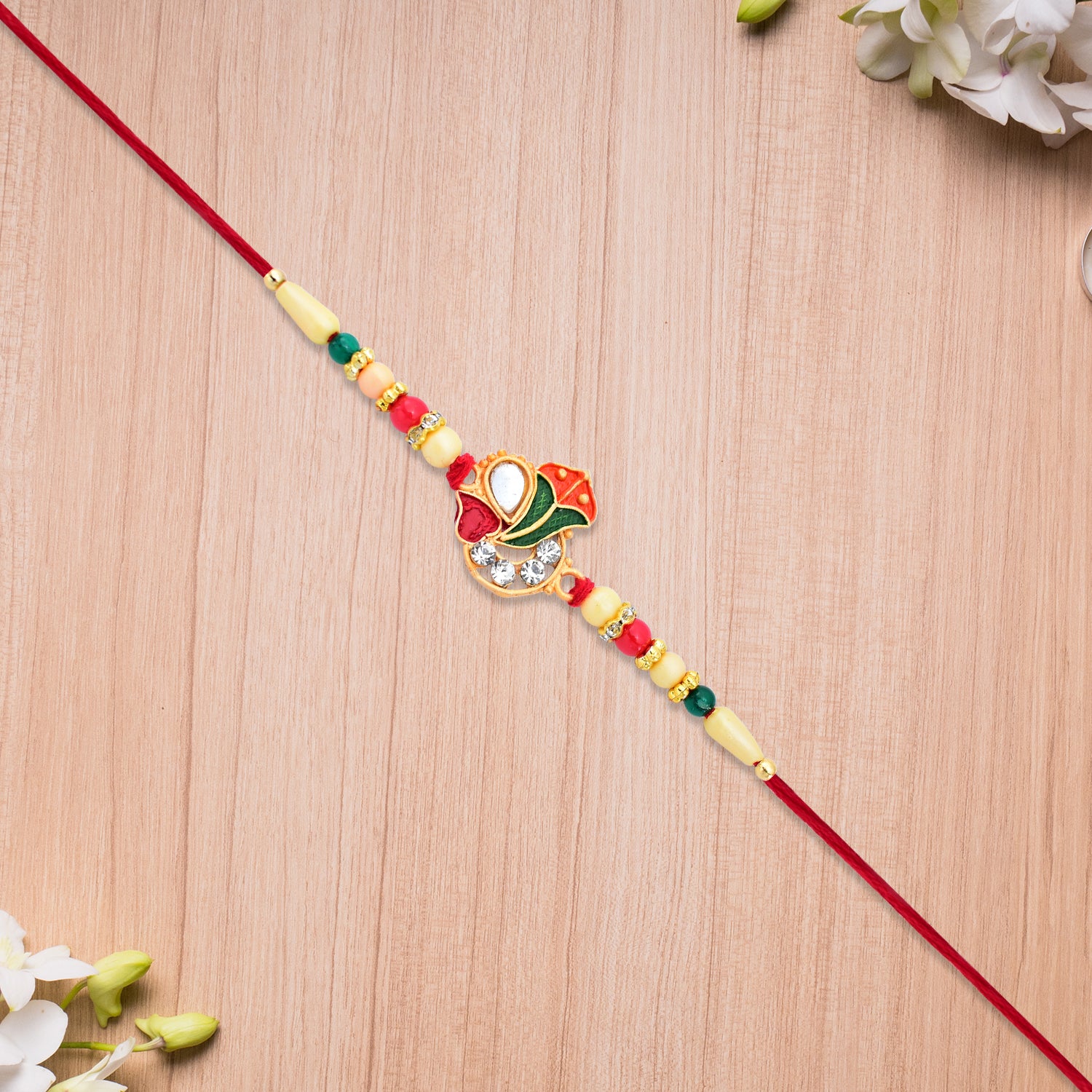 Divine Ganpati Rakhi With Enamel Work And Traditional Beads Divine Ganpati Rakhi With Enamel Work And Traditional Beads